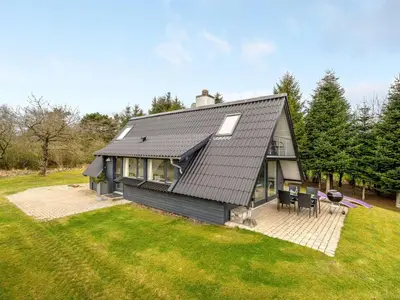 a black house with a patio and a yard at Holiday Home Brunhild - 300m to the fjord by Interhome in Fur