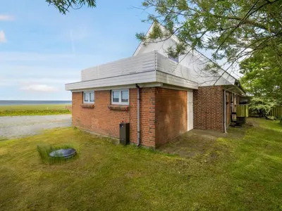 a brick house with a roof on a grass field at Holiday Home Emmie - 50m to the fjord by Interhome in Skarum