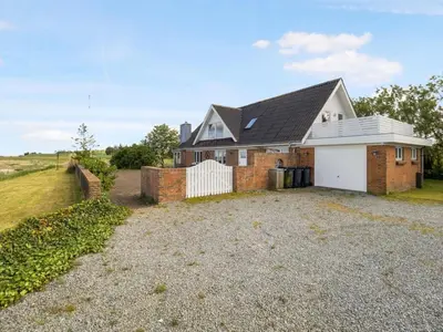 a large brick house with a white garage at Holiday Home Emmie - 50m to the fjord by Interhome in Skarum