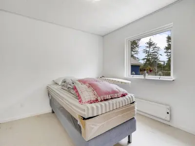 a bedroom with a bed in a room with a window at Holiday Home Mikkeline - 400m to the fjord by Interhome in Øster Assels