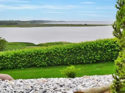 a large field of rocks next to a large body of water at Holiday Home Pirkka - 50m to the fjord by Interhome in Løgstrup