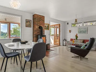 a living room with a table and chairs and a fireplace at Holiday Home Imgert - 300m to the fjord by Interhome in Løgstrup