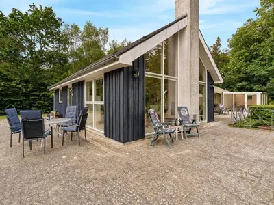 a patio with chairs and a table in front of a building at Holiday Home Ødger - 150m to the fjord by Interhome in Åbybro