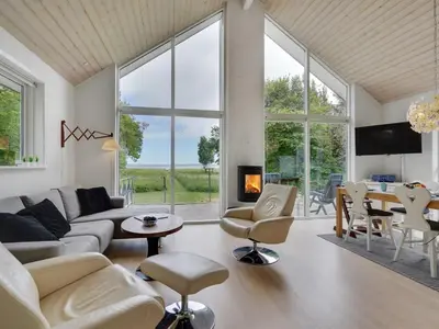 a living room with white furniture and large windows at Holiday Home Ødger - 150m to the fjord by Interhome in Åbybro