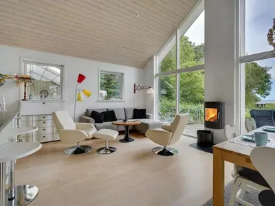 a living room with white furniture and a fireplace at Holiday Home Ødger - 150m to the fjord by Interhome in Åbybro