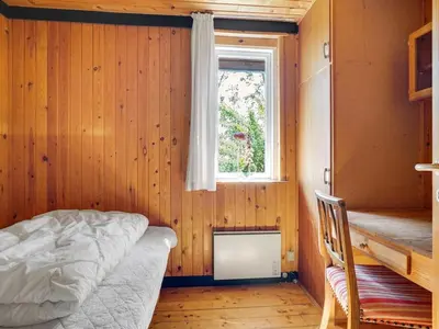 a bedroom with a bed and a window at Holiday Home Lennert - 100m to the fjord by Interhome in Åbybro