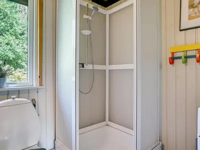 a shower in a bathroom with a toilet at Holiday Home Lennert - 100m to the fjord by Interhome in Åbybro