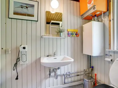 a bathroom with a sink and a mirror at Holiday Home Lennert - 100m to the fjord by Interhome in Åbybro