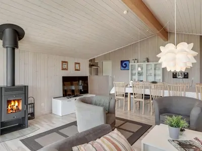a living room with a fireplace and a dining room at Holiday Home Richard - 4km from the sea by Interhome in Brovst