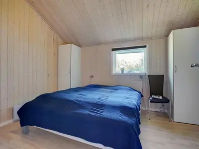 a bedroom with a blue bed in a room with a window at Holiday Home Jussi - 3-5km from the sea by Interhome in Brovst