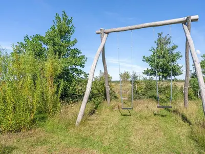 an empty swing in a field with trees at Holiday Home Ullvi - 3-8km from the sea by Interhome in Brovst
