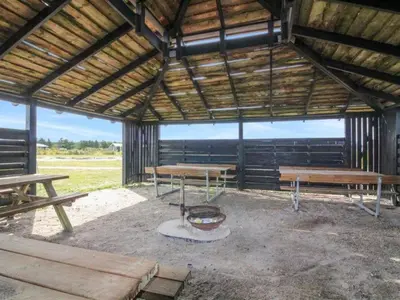 a pavilion with picnic tables and a fire pit at Holiday Home Ullvi - 3-8km from the sea by Interhome in Brovst