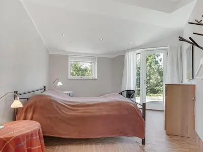 a bedroom with a large bed and a window at Holiday Home Ullvi - 3-8km from the sea by Interhome in Brovst