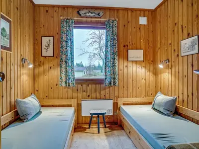 two beds in a room with a window at Holiday Home Carina - 5km from the sea by Interhome in Brovst