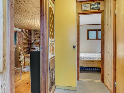 a room with a bed and a door to a bedroom at Holiday Home Carina - 5km from the sea by Interhome in Brovst