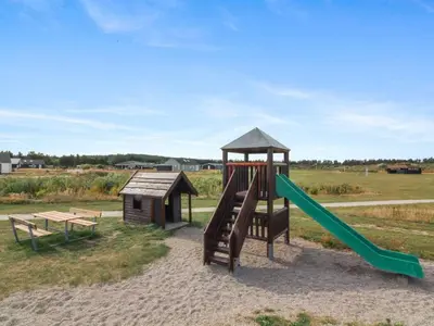 a playground with a slide and a bench at Holiday Home Asel - 4km from the sea by Interhome in Brovst
