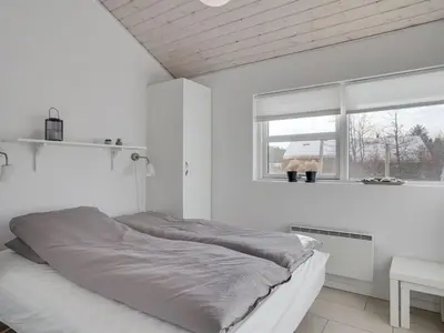 a white bedroom with a bed and a window at Holiday Home Asel - 4km from the sea by Interhome in Brovst
