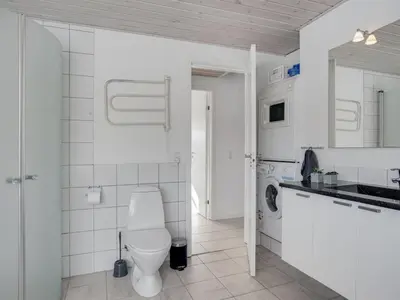 a white bathroom with a toilet and a sink at Holiday Home Asel - 4km from the sea by Interhome in Brovst