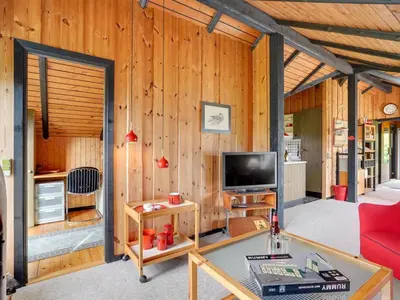 a living room with wood paneling and a television at Holiday Home Tenho - 4-4km from the sea by Interhome in Brovst