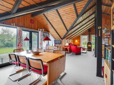 a living room with a wooden table and chairs at Holiday Home Tenho - 4-4km from the sea by Interhome in Brovst
