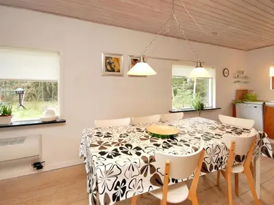 a kitchen and dining room with a table and chairs at Holiday Home Rigitte - 1-5km from the sea by Interhome in Pandrup