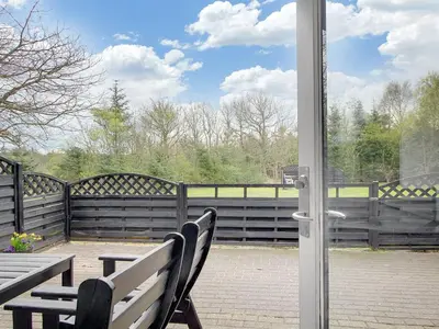 a door open to a patio with a bench and a table at Holiday Home Rigitte - 1-5km from the sea by Interhome in Pandrup