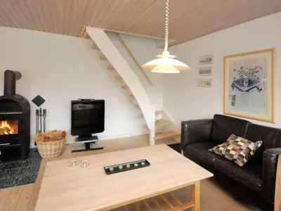 a living room with a couch and a fireplace at Holiday Home Rigitte - 1-5km from the sea by Interhome in Pandrup