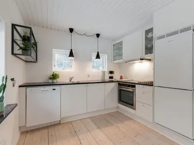 a white kitchen with white cabinets and appliances at Holiday Home Rigitte - 1-5km from the sea by Interhome in Pandrup