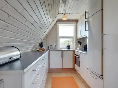 a kitchen with white cabinets and a large window at Holiday Home Viona - 350m from the sea by Interhome in Pandrup