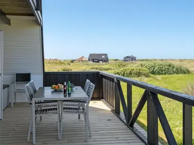 a wooden deck with a table and chairs on it at Holiday Home Viona - 350m from the sea by Interhome in Pandrup