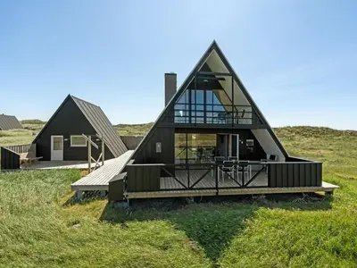 a house with a triangular roof on a field at Holiday Home Viona - 350m from the sea by Interhome in Pandrup