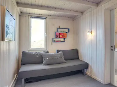 a bench in a corner of a room with a window at Holiday Home Fanney - 100m from the sea by Interhome in Pandrup