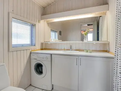 a bathroom with a washing machine and a sink at Holiday Home Fanney - 100m from the sea by Interhome in Pandrup