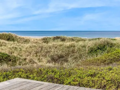 a view of the beach from a wooden deck at Holiday Home Tinea - 50m from the sea by Interhome in Pandrup
