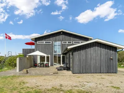 a large building with a flag on top of it at Holiday Home Tinea - 50m from the sea by Interhome in Pandrup