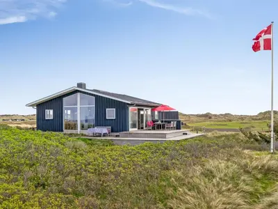 a house on the beach with a flag at Holiday Home Tinea - 50m from the sea by Interhome in Pandrup