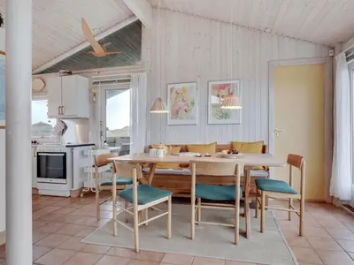 a kitchen and dining room with a table and chairs at Holiday Home Eri - 300m from the sea by Interhome in Pandrup