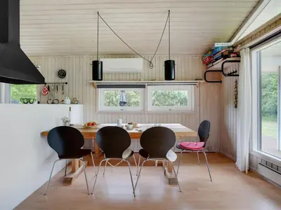 a kitchen with a dining room table and chairs at Holiday Home Evan - 1-3km from the sea by Interhome in Pandrup