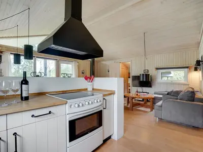 a kitchen with a stove top oven next to a living room at Holiday Home Evan - 1-3km from the sea by Interhome in Pandrup