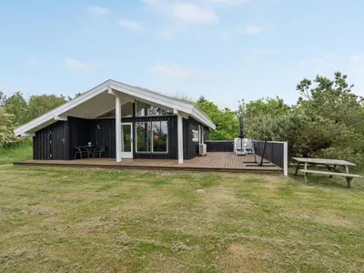 a small house with a deck and a bench at Holiday Home Evan - 1-3km from the sea by Interhome in Pandrup