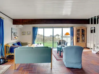 a living room with blue chairs and a bedroom at Holiday Home Emiline - 250m from the sea by Interhome in Saltum