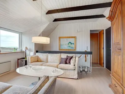 a living room with a couch and a table at Holiday Home Emiline - 250m from the sea by Interhome in Saltum