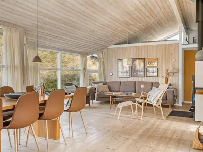 a living room with a table and chairs at Holiday Home Nielsigne - 400m from the sea by Interhome in Blokhus
