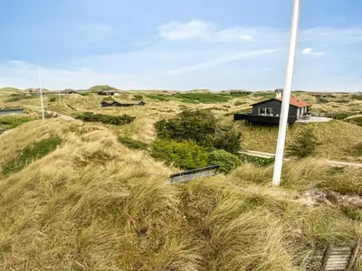 a house on top of a hill with grass at Holiday Home Nielsigne - 400m from the sea by Interhome in Blokhus