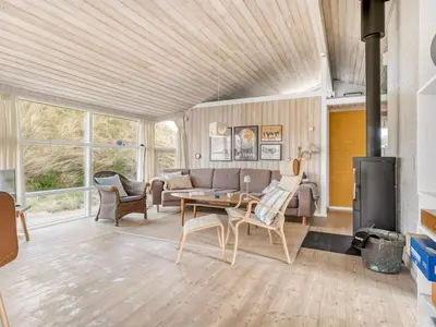 a living room with a couch and a table at Holiday Home Nielsigne - 400m from the sea by Interhome in Blokhus