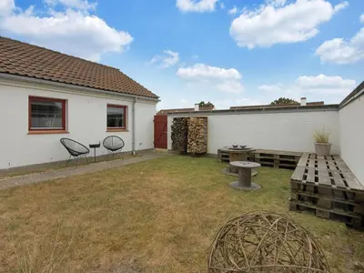 a backyard with a picnic table and chairs and a building at Holiday Home Frieda - 7-2km from the sea by Interhome in Pandrup