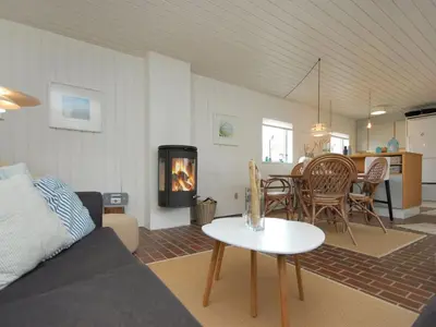 a living room with a couch and a table with a fireplace at Holiday Home Frieda - 7-2km from the sea by Interhome in Pandrup