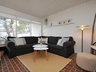 a living room with a black couch and a table at Holiday Home Frieda - 7-2km from the sea by Interhome in Pandrup