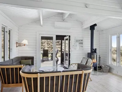 a living room with a table and a fireplace at Holiday Home Baltur - 650m from the sea by Interhome in Saltum
