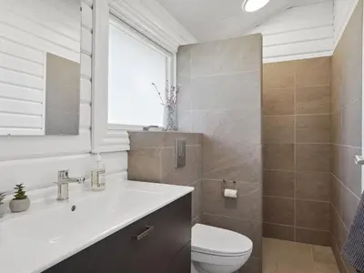 a bathroom with a sink and a toilet at Holiday Home Baltur - 650m from the sea by Interhome in Saltum